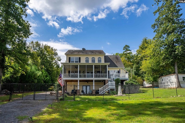 rear view of property featuring a yard, a sunroom, a gate, fence private yard, and stairs