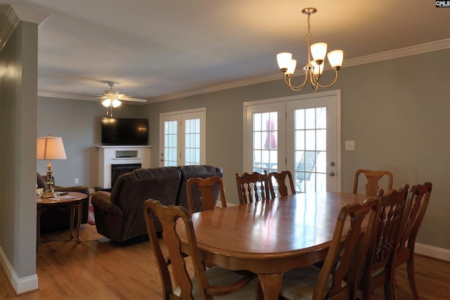 dining area featuring crown molding, a fireplace, and wood finished floors