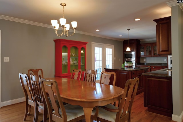 dining space with recessed lighting, crown molding, and light wood-style flooring