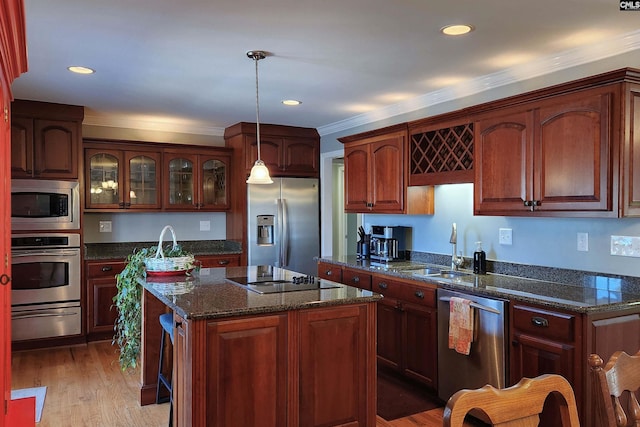 kitchen with pendant lighting, a warming drawer, appliances with stainless steel finishes, glass insert cabinets, and a kitchen island