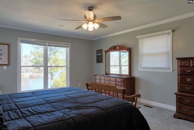 carpeted bedroom featuring a ceiling fan, crown molding, and baseboards