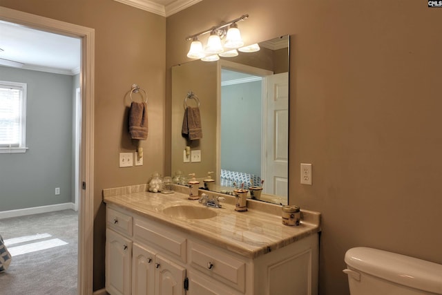 bathroom with baseboards, crown molding, vanity, and toilet