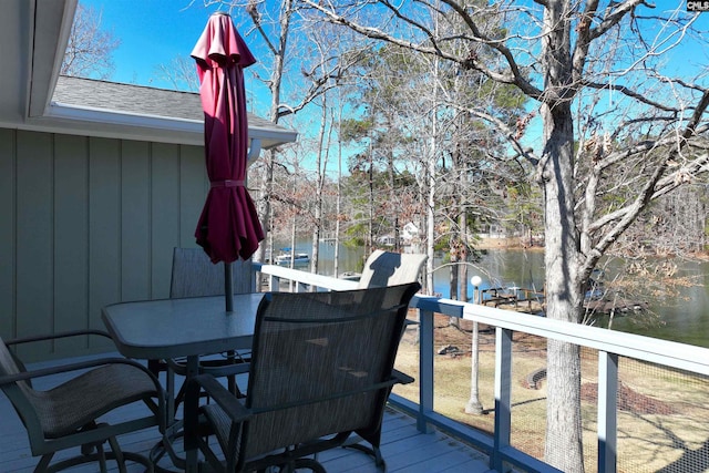 deck featuring outdoor dining area and a water view