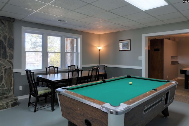 recreation room featuring finished concrete flooring, a paneled ceiling, visible vents, and baseboards