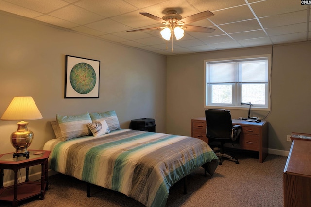 bedroom with carpet floors, a paneled ceiling, baseboards, and a ceiling fan