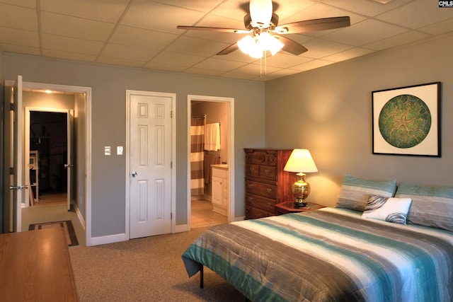 bedroom featuring a paneled ceiling, light colored carpet, connected bathroom, and baseboards