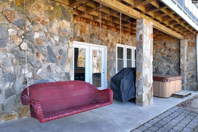 view of patio featuring french doors, a hot tub, and grilling area