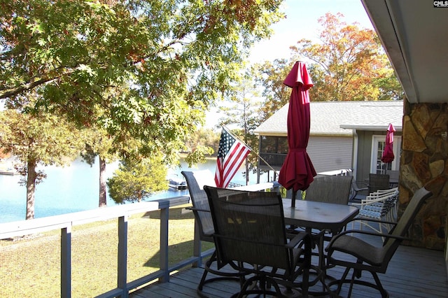 deck featuring outdoor dining space and a water view