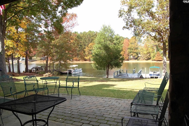 view of home's community with a water view, a patio, and a yard