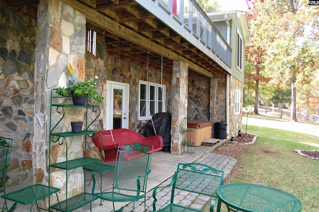 view of patio featuring a hot tub, grilling area, and a balcony