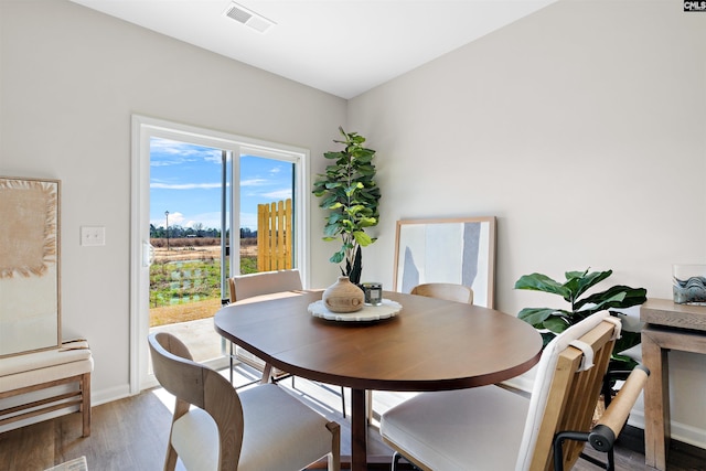 dining area featuring baseboards, wood finished floors, and visible vents