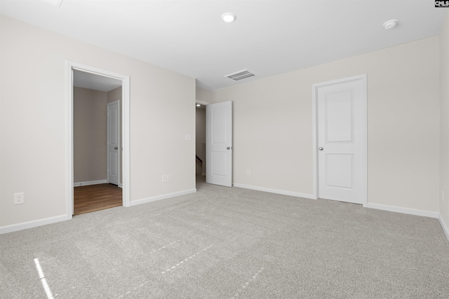 unfurnished bedroom featuring carpet floors, visible vents, and baseboards