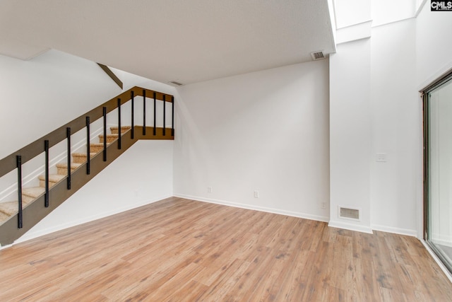 interior space with baseboards, visible vents, and wood finished floors