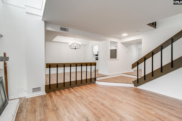 below grade area featuring stairs, visible vents, baseboards, and wood finished floors