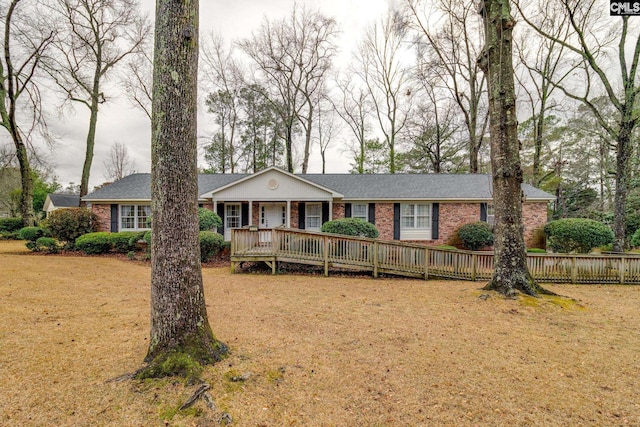 ranch-style home featuring brick siding, a front yard, and fence