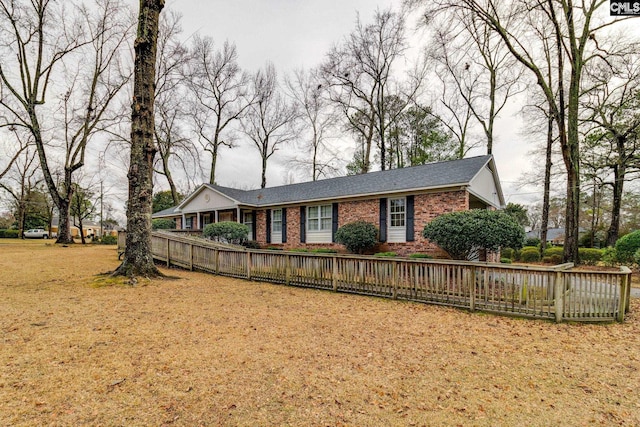 ranch-style house with fence private yard, a front yard, and brick siding