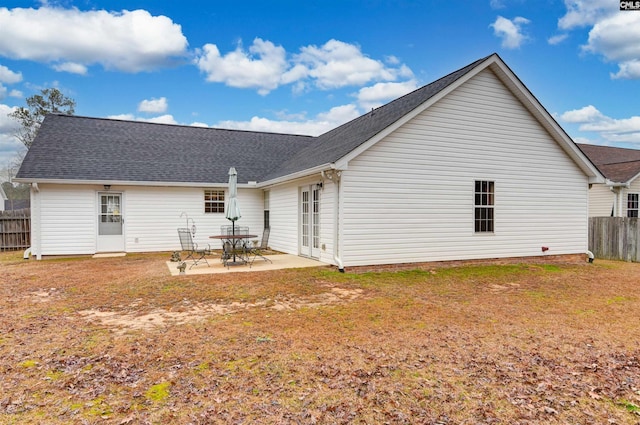 back of house with a patio area, a shingled roof, fence, and a lawn