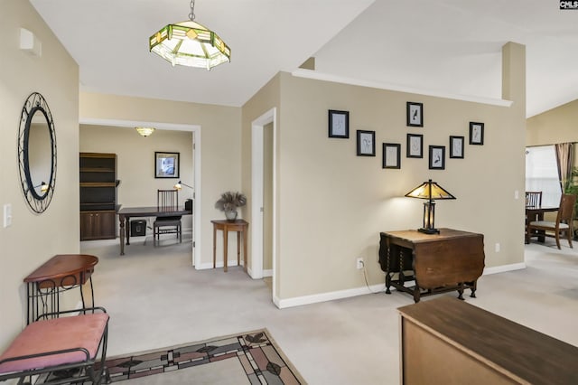 foyer featuring baseboards and light colored carpet