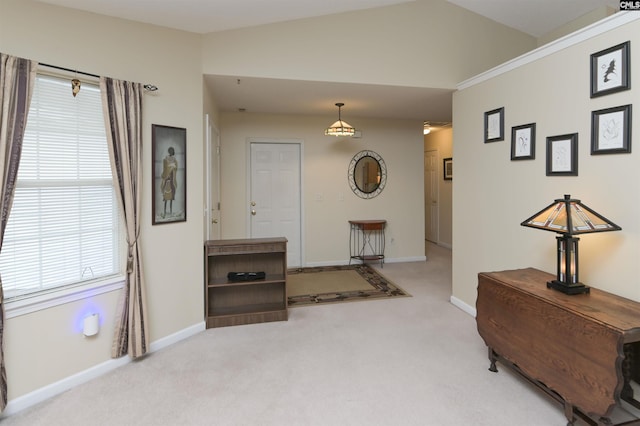 entrance foyer featuring baseboards, vaulted ceiling, and light colored carpet