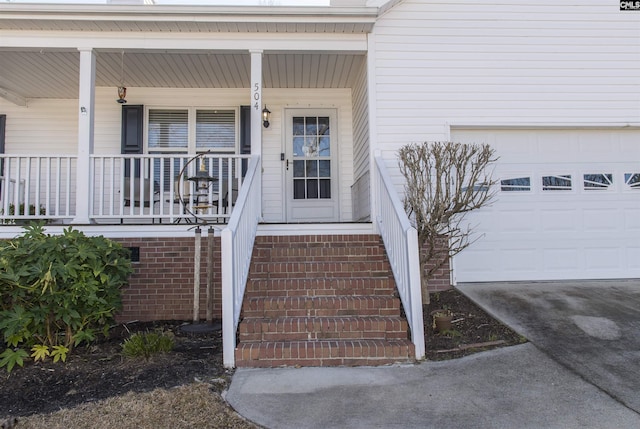 view of exterior entry featuring a garage and covered porch