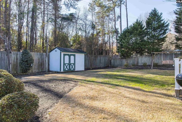 view of yard with an outbuilding, a fenced backyard, and a shed
