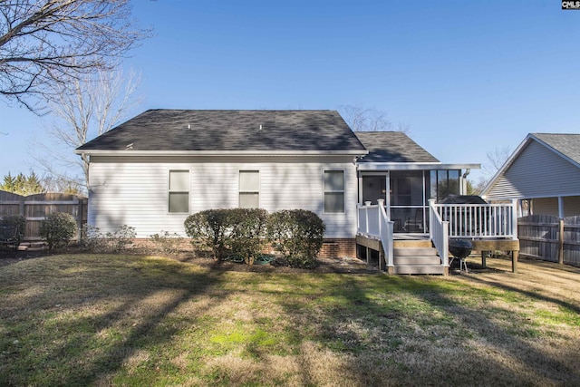 back of property with a yard, a sunroom, fence, and a wooden deck