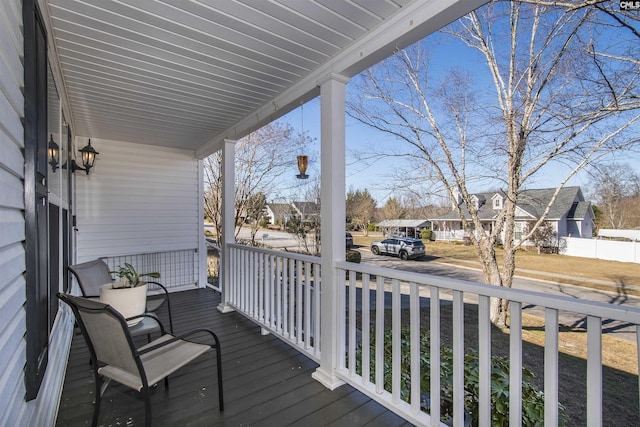 wooden terrace with a porch and a residential view