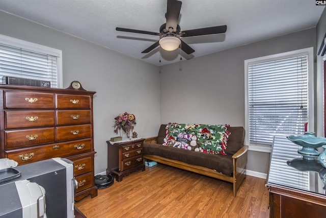 bedroom featuring light wood-type flooring, a ceiling fan, and baseboards