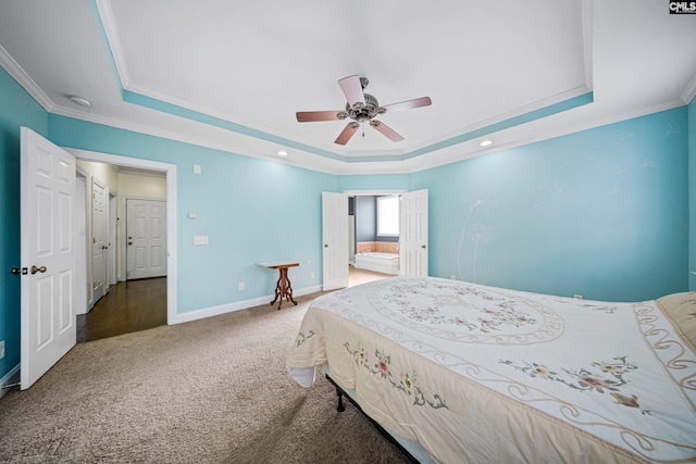 carpeted bedroom with baseboards, ornamental molding, a raised ceiling, and connected bathroom