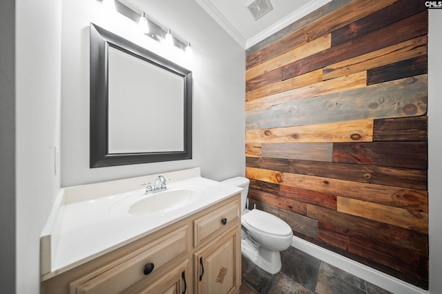 half bathroom featuring crown molding, visible vents, toilet, wooden walls, and vanity