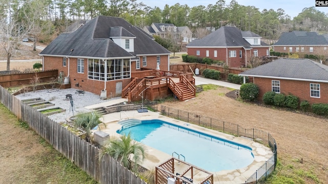 back of house featuring a fenced backyard, brick siding, stairway, a wooden deck, and a patio area