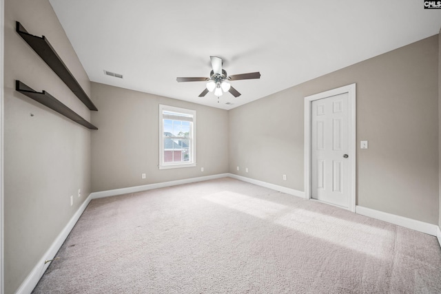 carpeted empty room with a ceiling fan, visible vents, and baseboards