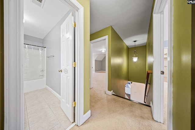 corridor with baseboards, visible vents, tile patterned floors, an upstairs landing, and carpet floors