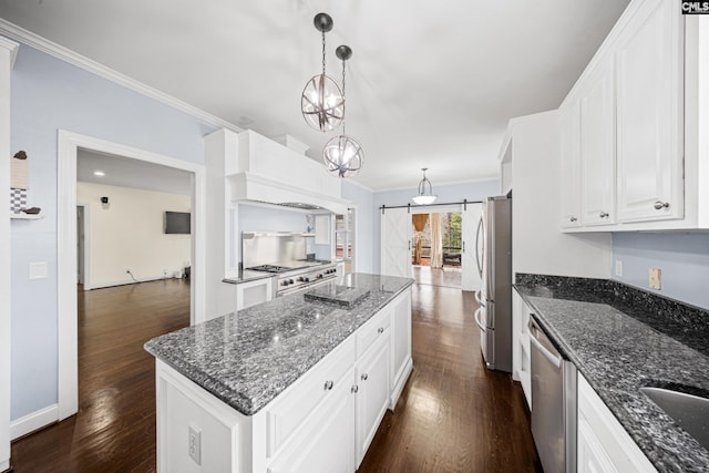 kitchen featuring dark wood-style floors, a barn door, a kitchen island, and appliances with stainless steel finishes