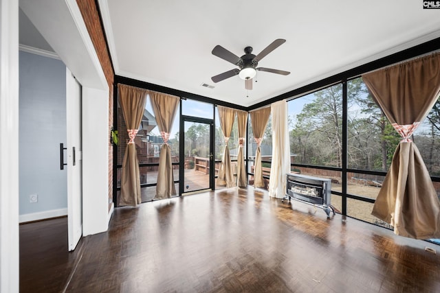 interior space featuring ornamental molding, expansive windows, a wood stove, and baseboards