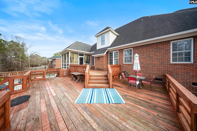 wooden terrace featuring a sunroom and fence