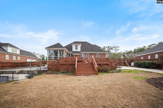 rear view of house with stairway, a sunroom, a patio area, a fenced backyard, and a wooden deck