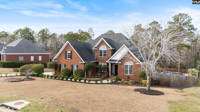 traditional home with brick siding and fence