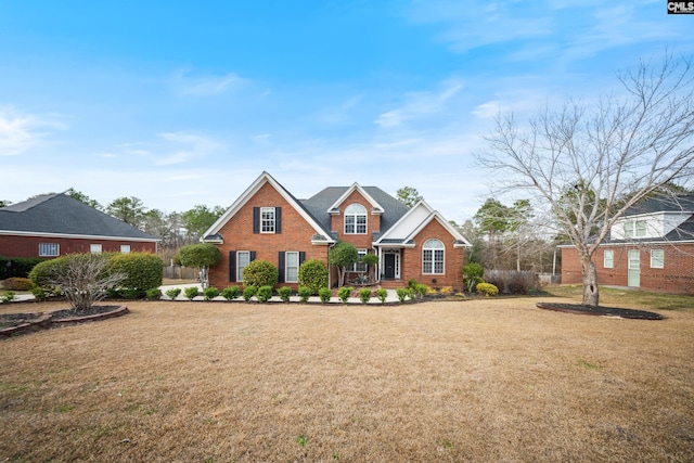 traditional-style home with brick siding and a front yard