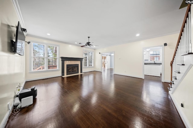 living area featuring ornamental molding, stairway, a fireplace with flush hearth, and wood finished floors