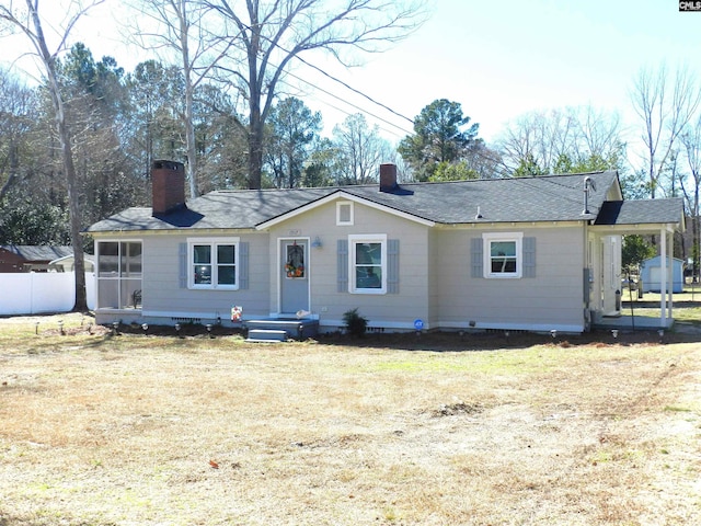 single story home with an attached carport, a chimney, a front yard, and fence