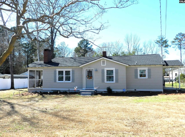 view of front of house with a front lawn, a chimney, and a shingled roof