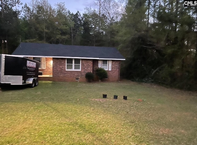 single story home featuring an attached carport, crawl space, brick siding, and a front lawn