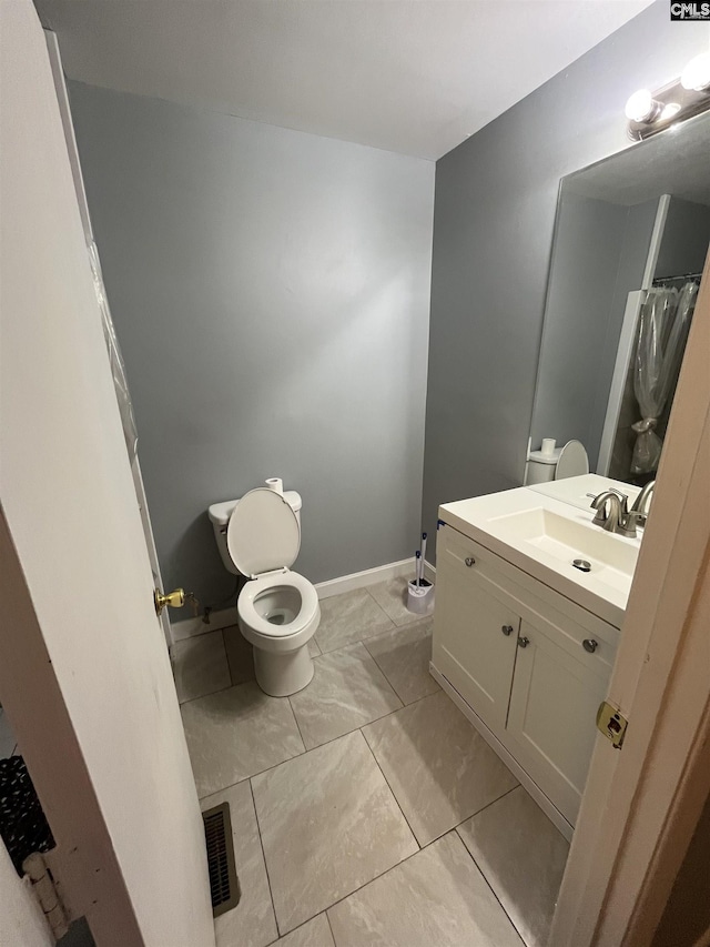 bathroom with baseboards, visible vents, vanity, and toilet