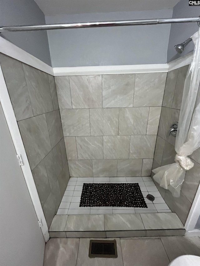 bathroom with a shower stall and visible vents