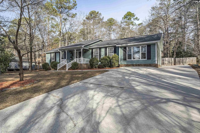 ranch-style house with driveway and fence