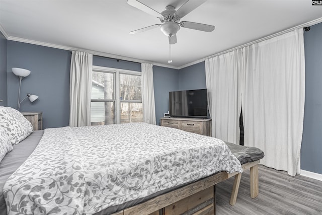 bedroom with ceiling fan, baseboards, crown molding, and wood finished floors