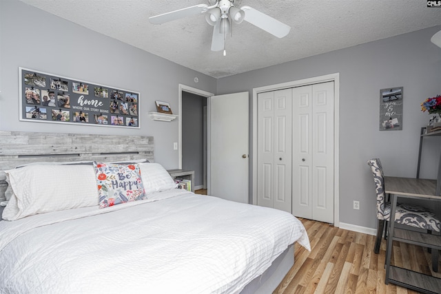 bedroom featuring a textured ceiling, light wood finished floors, a closet, and a ceiling fan