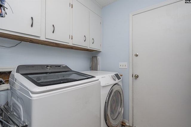 washroom with washer and dryer and cabinet space