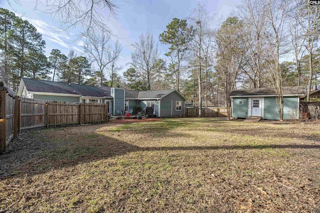 view of yard with a fenced backyard and an outbuilding